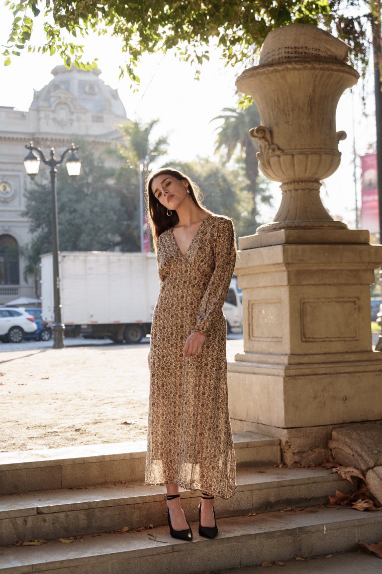 Vestido de seda estampada a contraluz junto a una urna de piedra.